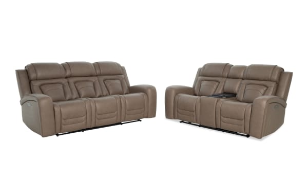 Two taupe brown leather reclining sofas with plush cushioning and stitched detailing, featuring cup holders and a center console on one sofa.