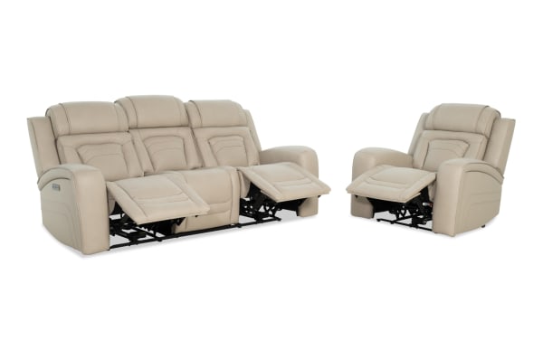 Beige leather reclining sofa and armchair set with padded cushions and footrests extended, showcasing modern comfort and style.