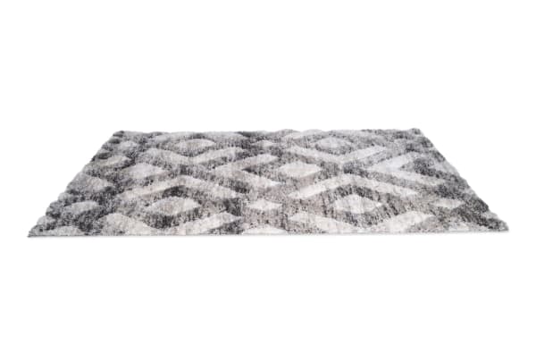 Rectangular gray and white shag area rug with a geometric diamond pattern, soft plush texture, suitable for living room or bedroom decor.