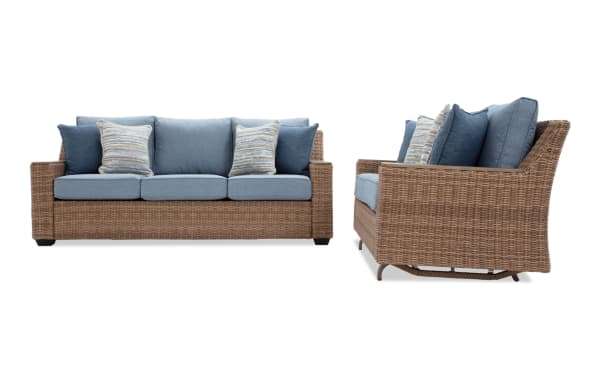 Three-seat outdoor wicker sofa with blue cushions and striped throw pillows, featuring a sturdy woven rattan frame and plush back support.