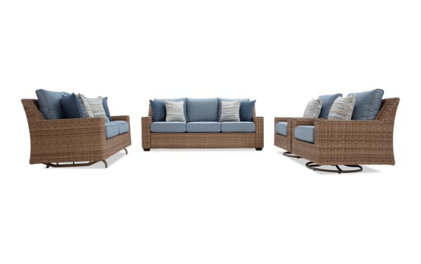 Outdoor patio furniture set including a wicker loveseat with blue cushions, a matching three-seater sofa, and two swivel chairs with striped pillows.