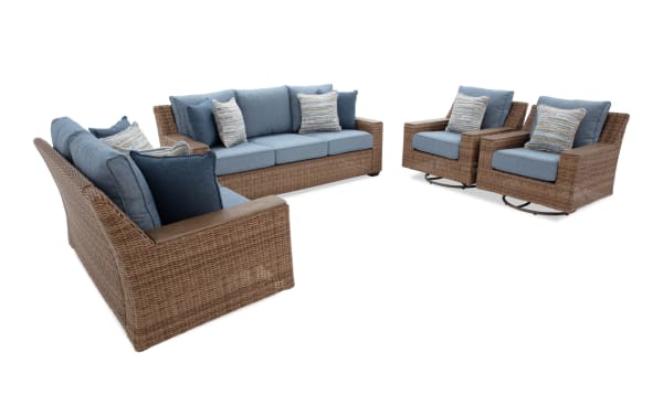 Outdoor patio furniture set with woven rattan frames, blue cushions, and patterned throw pillows, including a sofa, loveseat, and two swivel chairs.