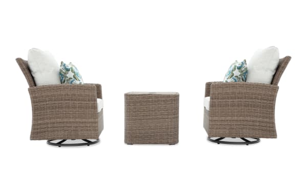 Outdoor patio set with two swivel wicker armchairs in light brown and beige cushions, featuring decorative leaf-patterned throw pillows, and a matching square wicker side table.