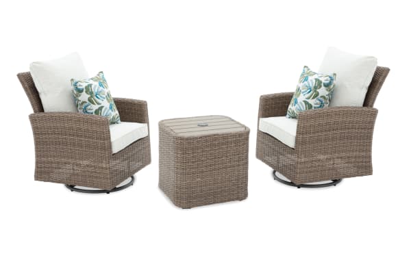 Outdoor patio set featuring two swivel armchairs and a matching square side table, all with brown wicker frames and white cushions with tropical leaf-patterned accent pillows.