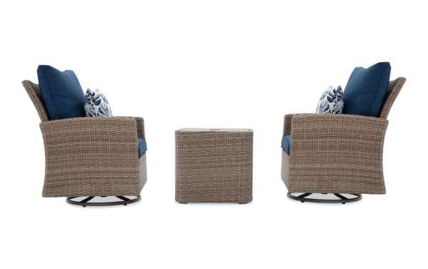 Two brown wicker swivel chairs with blue cushions and patterned throw pillows, paired with a matching square wicker side table.
