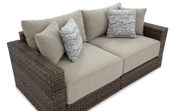 Modular Bob® 2 Piece Beige & Brown Wicker Outdoor Loveseat with all-weather wicker, rust-proof aluminum frame, beige polyester cushions, and patterned throw pillows.