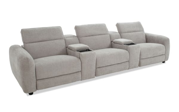 Modern three-seat beige fabric reclining sofa with wide armrests, integrated cup holders, and plush cushioning for living room comfort.