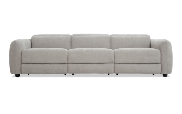 Modern light gray fabric sofa with plush cushions, wide armrests, and low black legs, designed for comfortable living room seating.