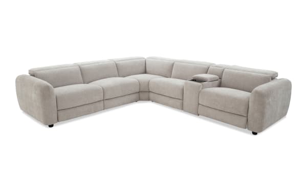 Sectional sofa in light beige fabric upholstery with plush cushions, rounded armrests, and a built-in center console with storage and cup holders, ideal for modern living rooms.