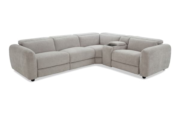 Modern L-shaped sectional sofa in light gray fabric upholstery with plush cushions, rounded armrests, and a built-in center console for storage and cup holders.