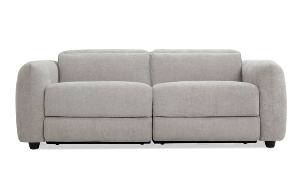 Modern light gray fabric sofa with wide armrests, plush cushions, and low black legs, ideal for contemporary living rooms.