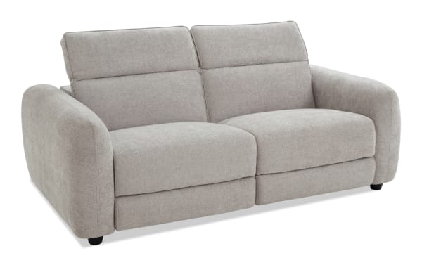 Modern beige fabric loveseat sofa with plush cushions, wide armrests, and a comfortable reclining feature, ideal for living room seating.