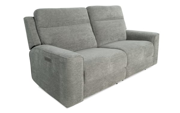 Modern gray fabric reclining sofa with padded armrests and adjustable headrests, designed for comfort and relaxation.