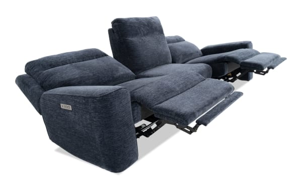 Dark blue fabric reclining sofa with padded armrests and backrests, featuring dual footrests extended for comfort and relaxation.