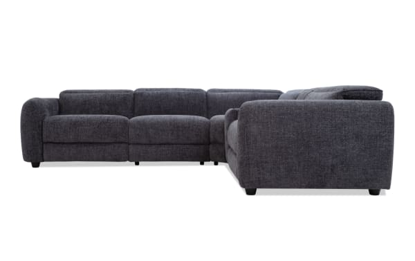 Dark gray fabric sectional sofa with plush cushions, rounded arms, and low black legs, designed for modern living room comfort.