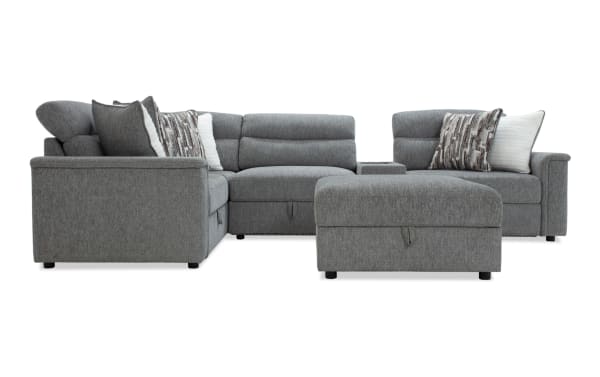 Gray fabric sectional sofa with adjustable headrests, patterned and white throw pillows, and a matching ottoman, ideal for modern living rooms.
