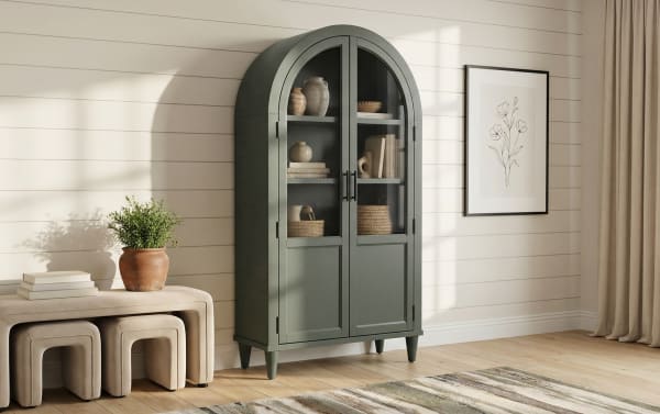 Domus Green Arch Cabinet in transitional style, made of rubberwood solids and MDF, featuring a tall, sleek green arched silhouette with glass doors for display and lower storage.