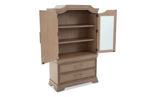 Wooden armoire with a natural oak finish, featuring two open doors revealing two shelves inside, a mirror on the right door, and two lower drawers with metal handles.