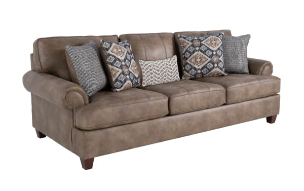 Raleigh Cognac 103'' traditional sofa in brown faux leather polyester fabric with rolled arms, plush cushions, and patterned accent pillows.