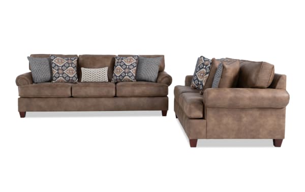 Brown leather sofa set with rolled arms, wooden legs, and multiple patterned throw pillows, showcasing a classic, comfortable living room style.