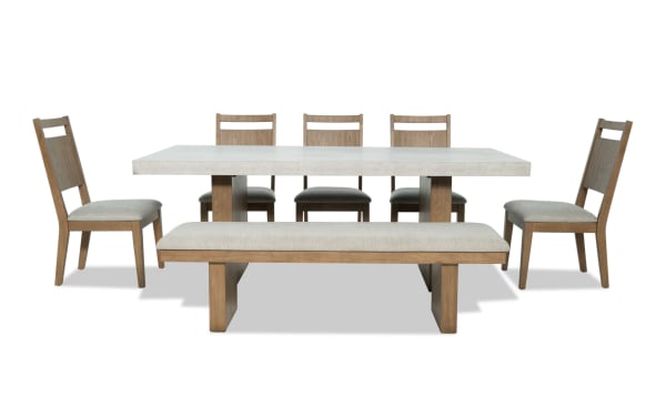 Monterey 7 Piece Natural & Gray Panel Back Upholstered Dining Set with Bench, featuring a faux concrete melamine tabletop, gray polyester fabric seats, and traditional rubberwood solid frame.
