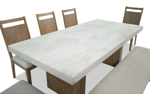 Monterey 7 Piece Natural & Gray Panel Back Upholstered Dining Set with Bench featuring a faux concrete melamine table top, gray polyester fabric chairs, and bench in traditional style.