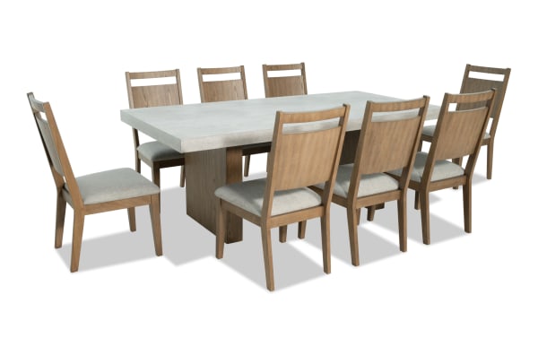 Monterey 9 Piece Natural & Gray Panel Back Upholstered Dining Set with faux concrete melamine table top and eight gray polyester fabric memory foam chairs.