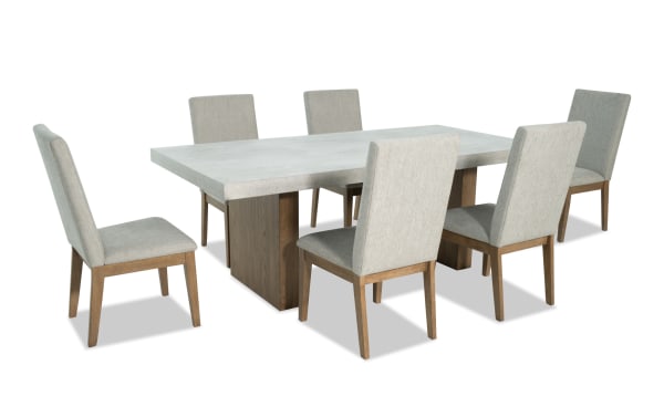 Monterey 7 Piece Natural & Gray Solid Back Upholstered Dining Set with faux concrete melamine table top and six gray polyester fabric chairs with memory foam.