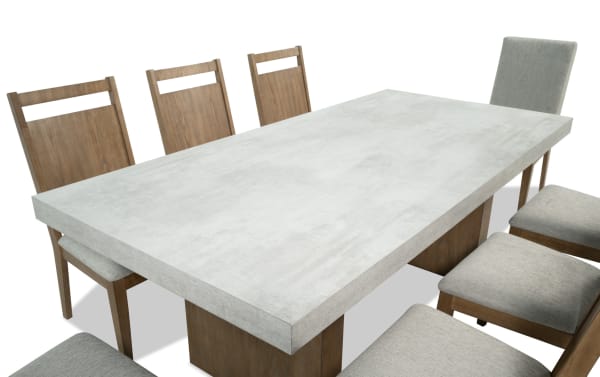 Monterey 9 Piece Natural & Gray Upholstered Dining Set with faux concrete melamine tabletop, gray polyester fabric chairs, and traditional wood frame.