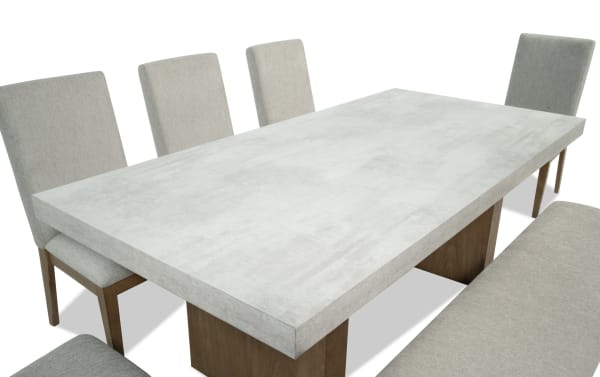 Monterey 7 Piece Natural & Gray Upholstered Dining Set with faux concrete melamine table top, gray polyester fabric chairs, and matching bench in traditional style.