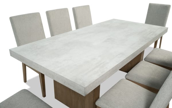 Monterey 9 Piece Natural & Gray Solid Back Upholstered Dining Set with faux concrete melamine table top and eight gray polyester fabric chairs.