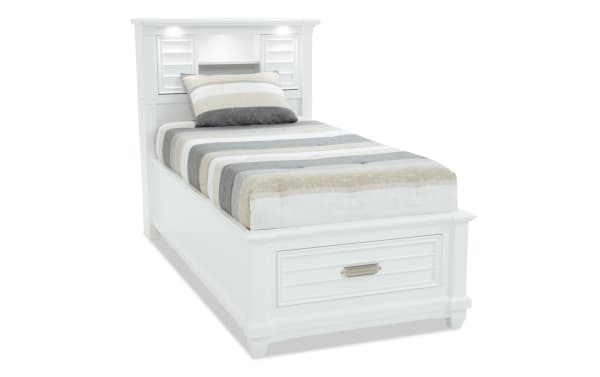 Sunset Cove Youth Twin White Bookcase Storage Bed in coastal style, MDF construction, with built-in storage drawer, LED lighting, power outlets, and USB/USB-C ports.