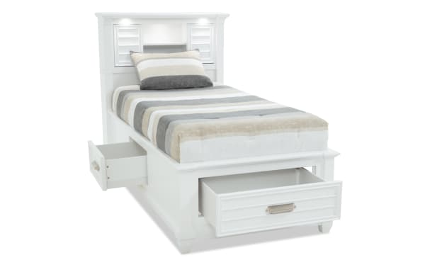 Sunset Cove Youth Twin white MDF storage bed with coastal style, built-in bookcase headboard, LED lighting, USB/USB-C ports, and 3 smooth-glide drawers.