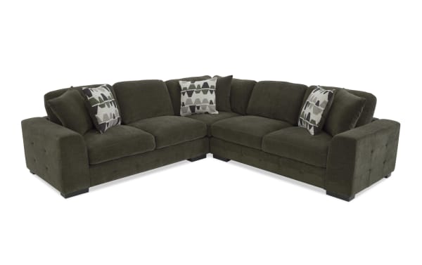 Dark olive green fabric sectional sofa with tufted armrests, plush cushions, and patterned accent pillows, designed for modern living rooms.