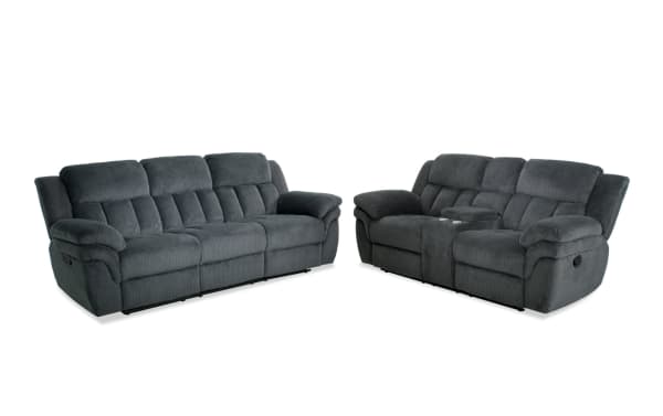 Dark gray fabric reclining sofa set with plush cushioned seats and armrests, featuring a three-seater sofa and a loveseat with center console and cup holders.