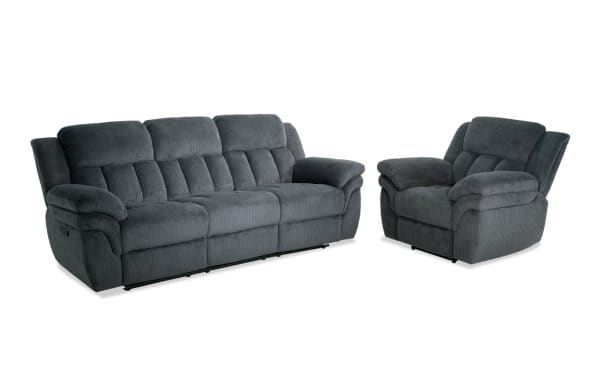 Dark gray fabric reclining sofa and matching armchair with plush cushioning and padded armrests, designed for living room comfort.