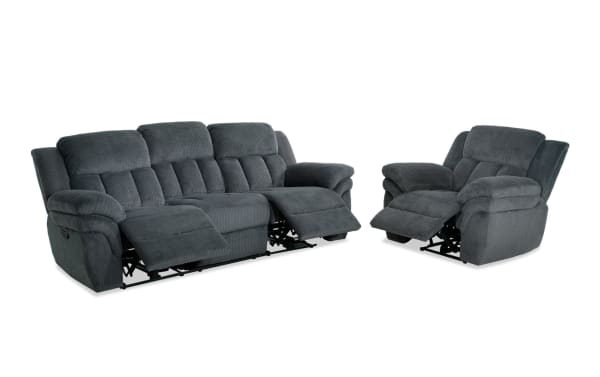 Dark gray fabric reclining sofa and armchair set with plush cushioning, padded armrests, and segmented backrests, designed for living room comfort.