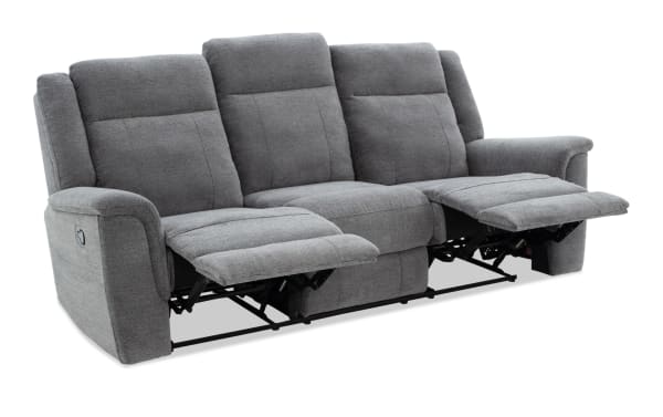 Gray fabric reclining sofa with three seats, padded armrests, and visible metal reclining mechanisms, designed for living room comfort.