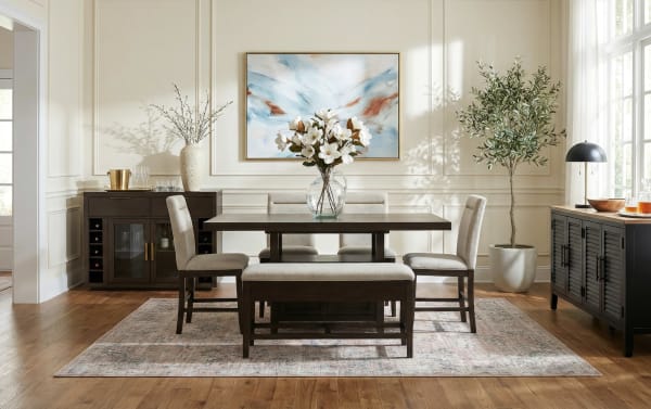 Modern dining room with dark wood table, beige upholstered chairs and bench, floral centerpiece, abstract wall art, and natural light.