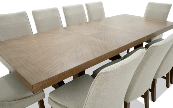 Melrose 11 Piece Natural & Beige Solid Back Extendable Dining Set with rectangular wood table, beige polyester fabric chairs, transitional style, memory foam cushions, and table leaf storage.