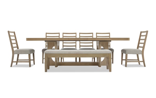 Dining set with a rectangular light wood table, six ladder-back chairs with beige cushioned seats, and a matching cushioned bench.