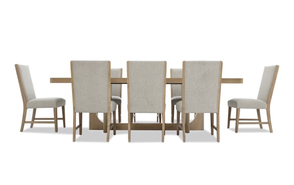 Dining set with eight beige upholstered chairs featuring wooden frames and a rectangular wooden table with a sturdy base, ideal for modern dining rooms.