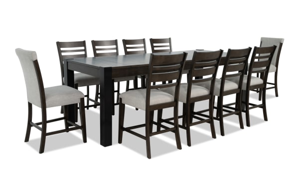 Aurora 11-piece transitional extendable dining set with brown and black MDF, rubberwood, gray polyester upholstery, memory foam stools, and lift-top storage.