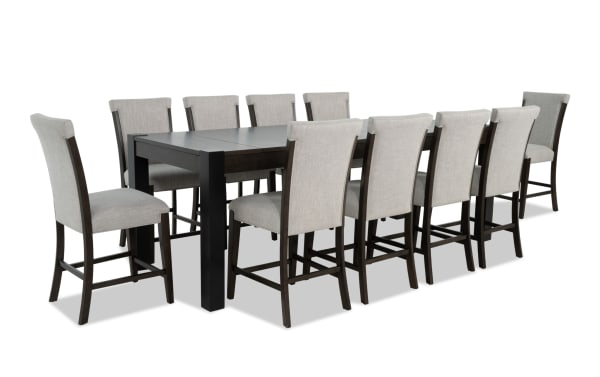 Aurora 11-piece gray transitional dining set with extendable 86"-102" brown-black MDF table, two lift-top storage compartments, and 10 gray polyester fabric stools with memory foam seats.
