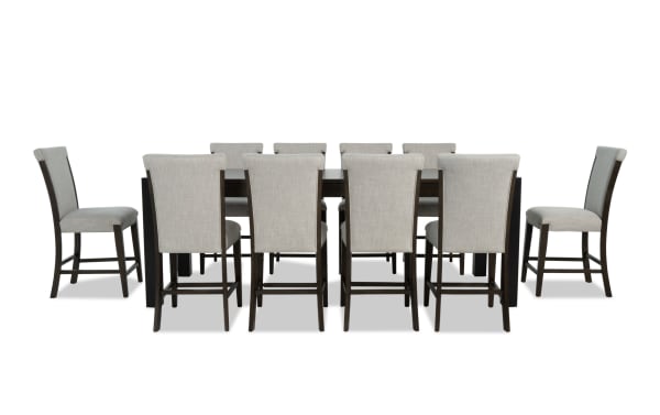 Aurora 11-piece transitional dining set with extendable brown-black MDF and rubberwood table, gray polyester fabric stools with memory foam seats, and lift-top storage compartments.
