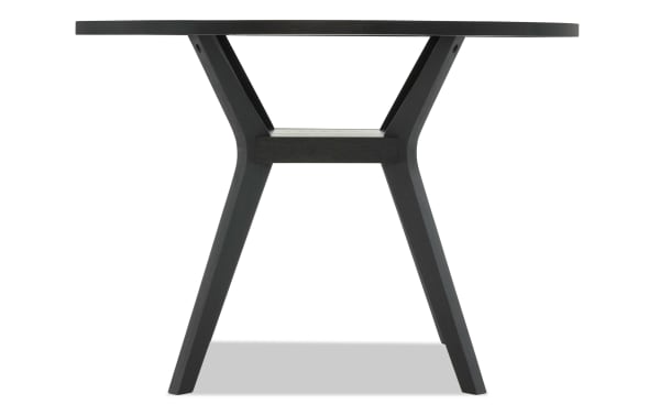 Black wooden round table with angled legs and a modern minimalist design, suitable for dining or office use.