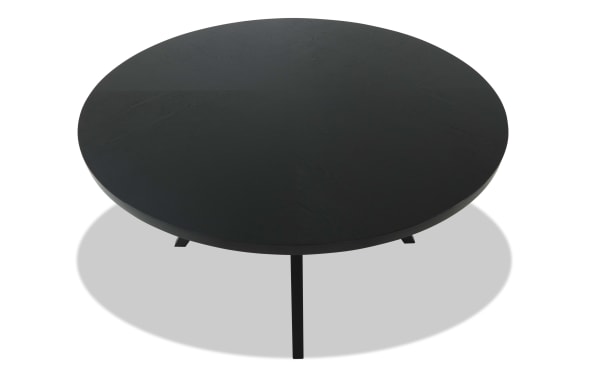 Round black wooden coffee table with a smooth matte finish and three slender legs, modern minimalist design.