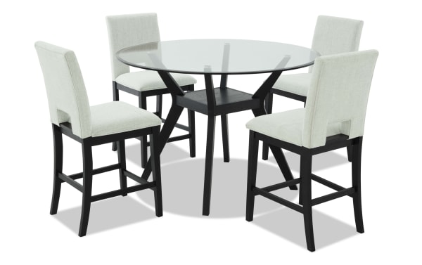 Round glass dining table set with four cushioned beige fabric chairs, black wooden legs, modern contemporary style, suitable for kitchen or dining room.