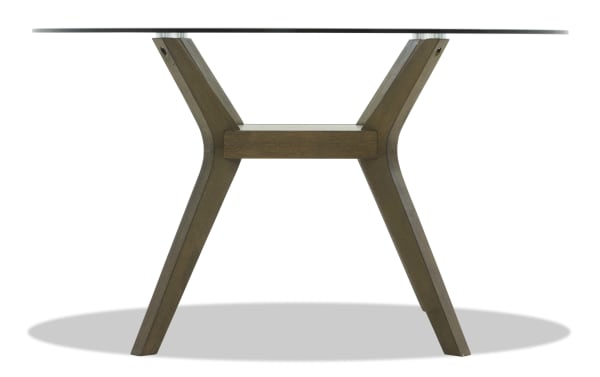 Round dining table with a clear glass top and angled dark wood legs in a modern, minimalist design.