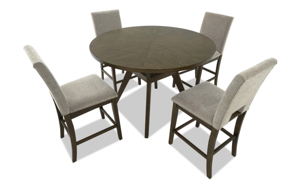 Round wooden dining table with dark brown finish, paired with four beige upholstered chairs featuring wooden legs, ideal for modern dining rooms.
